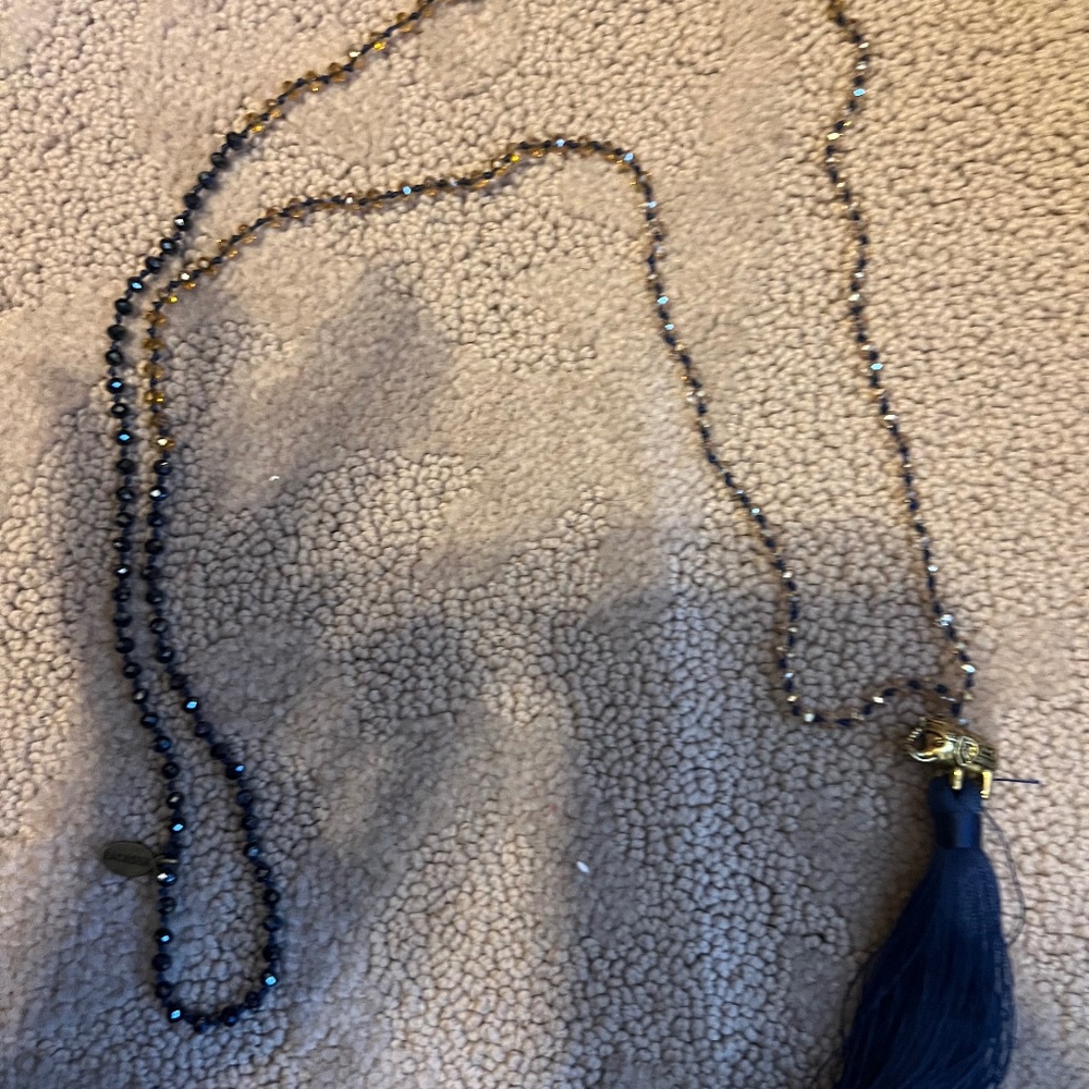 Beaded long necklace with blue tassel and elephant accent.